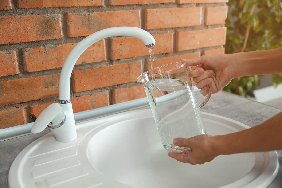 Wasserprobe wird an einem Wasserhahn in einem Privathaushalt entnommen.