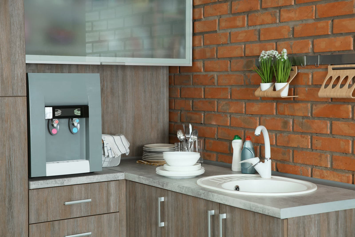 Auftisch-Wasserfilter auf einer Küchenarbeitsplatte neben der Spüle.