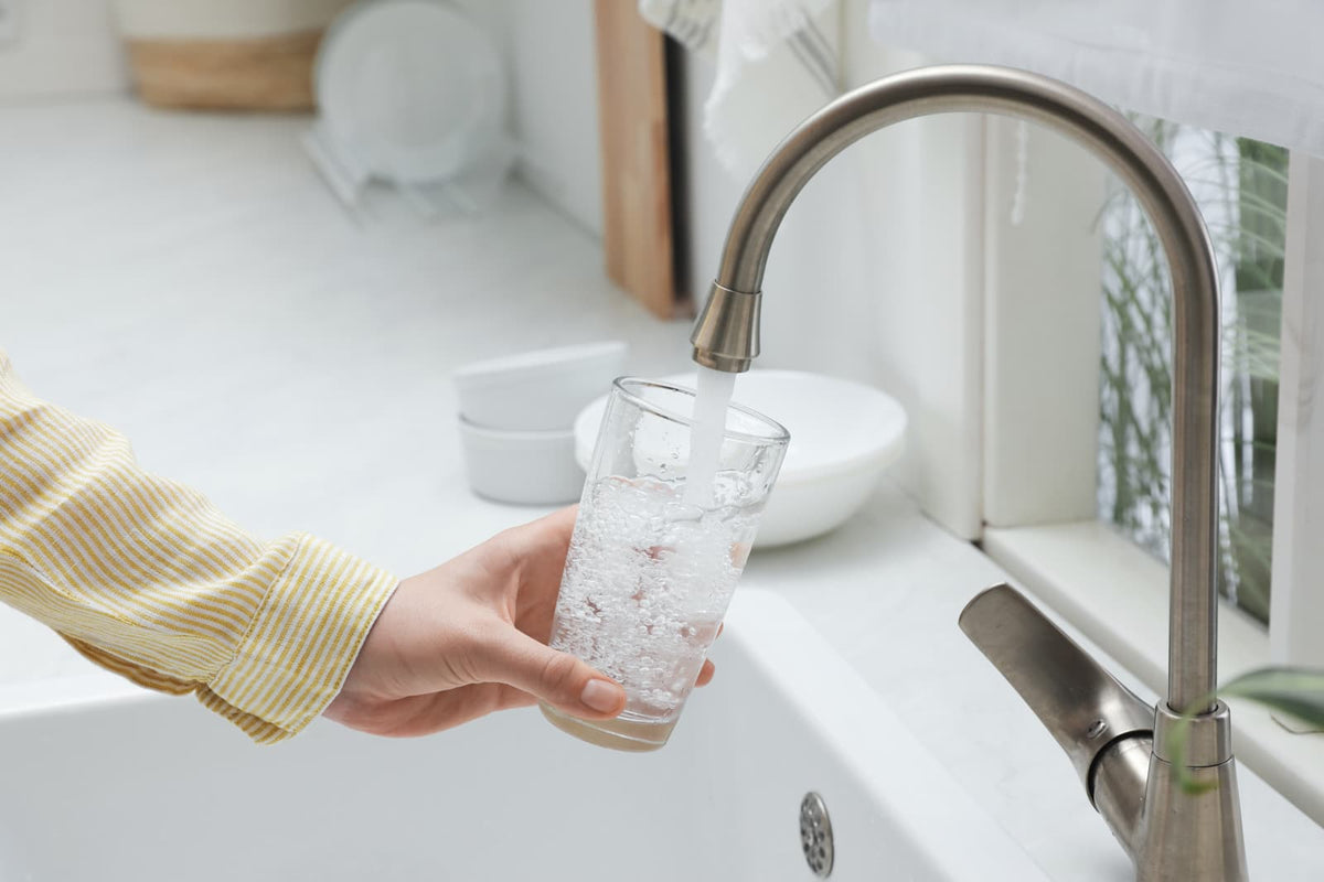 Wasser fließt aus einem Küchenhahn in einer modernen Wohnungsküche.